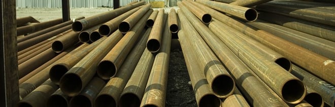 A stack of metal tubes stored in a yard